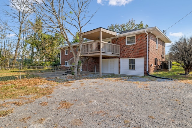 rear view of house featuring a wooden deck and cooling unit