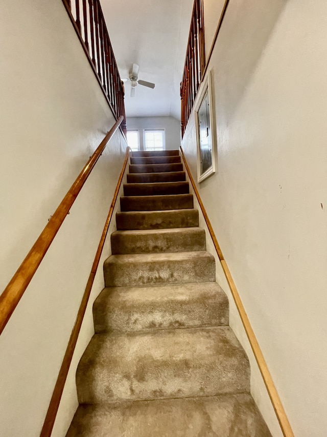 staircase featuring ceiling fan