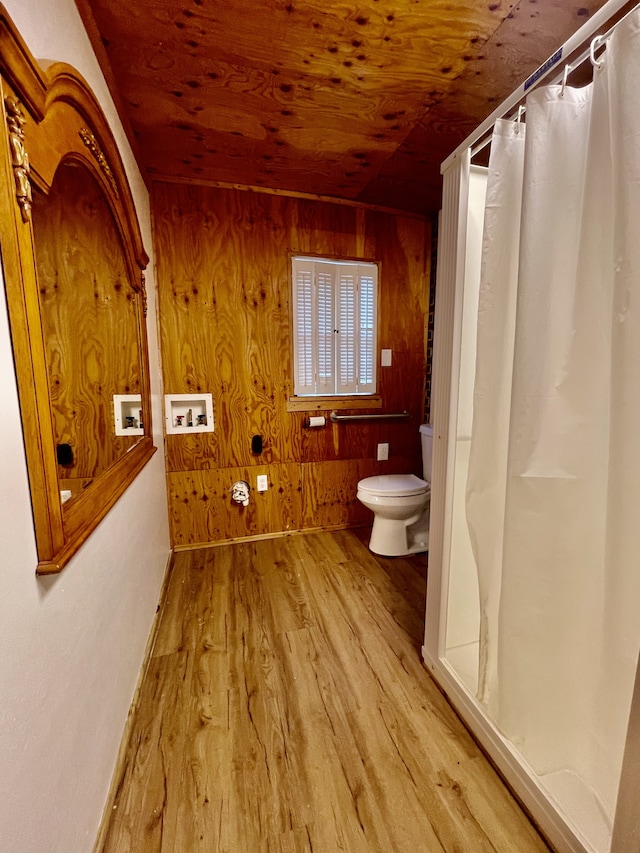 bathroom featuring wood walls, wood-type flooring, toilet, and wooden ceiling