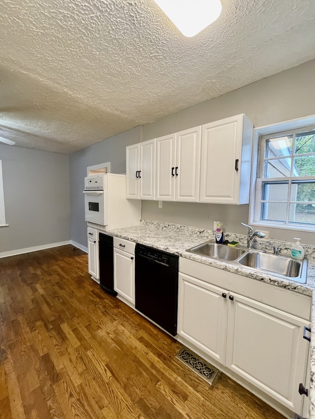 kitchen with oven, white cabinets, dark hardwood / wood-style floors, and black dishwasher