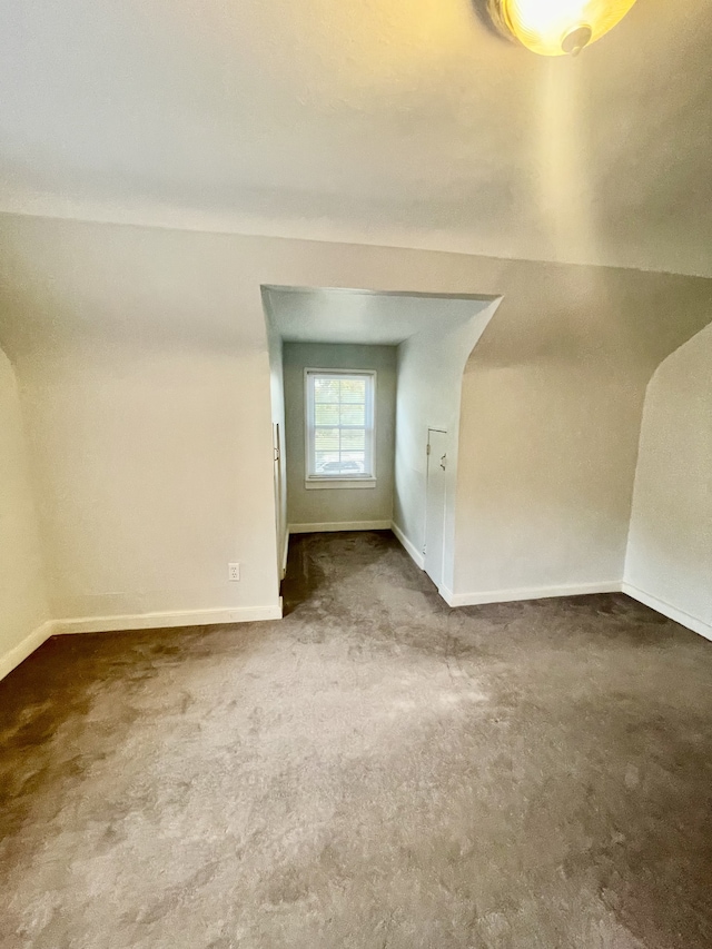 additional living space featuring carpet floors and vaulted ceiling