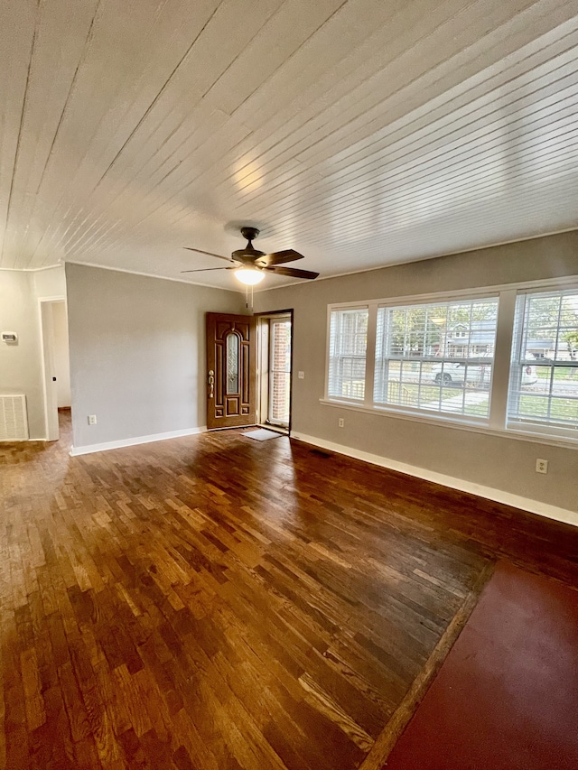 unfurnished living room with dark wood-type flooring, ceiling fan, and a wealth of natural light