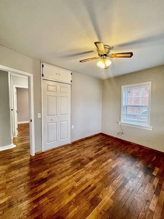 unfurnished bedroom with dark hardwood / wood-style flooring and ceiling fan