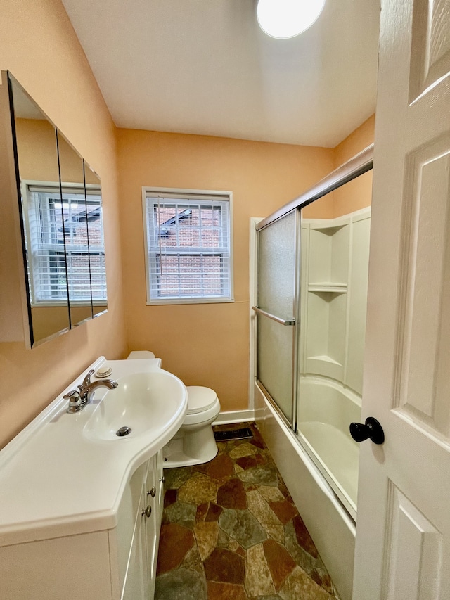 full bathroom with vanity, toilet, and shower / bath combination with glass door