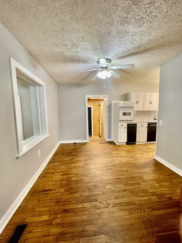 unfurnished living room featuring light hardwood / wood-style flooring, a textured ceiling, and ceiling fan