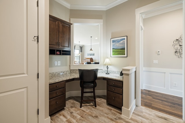 office area featuring light hardwood / wood-style flooring, built in desk, and ornamental molding