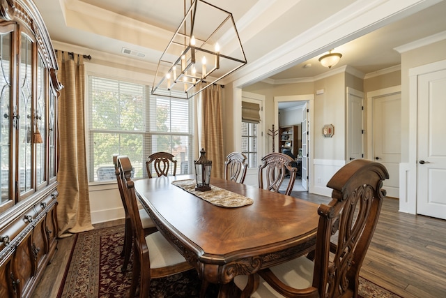 dining room featuring dark hardwood / wood-style floors, an inviting chandelier, a wealth of natural light, and crown molding