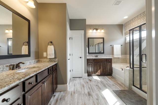 bathroom featuring hardwood / wood-style floors, vanity, and separate shower and tub