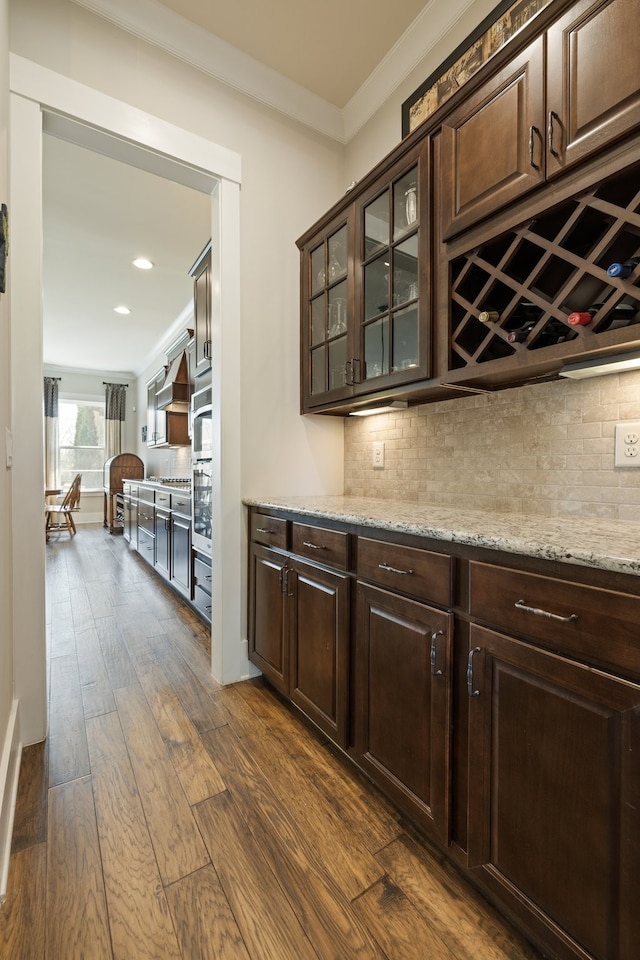 bar featuring dark brown cabinetry and dark wood-type flooring