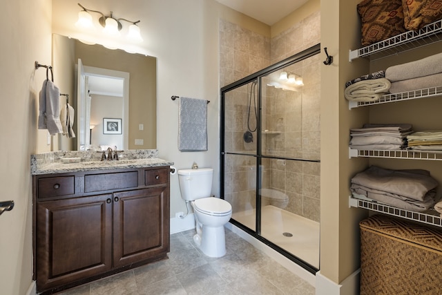 bathroom featuring tile patterned floors, vanity, an enclosed shower, and toilet