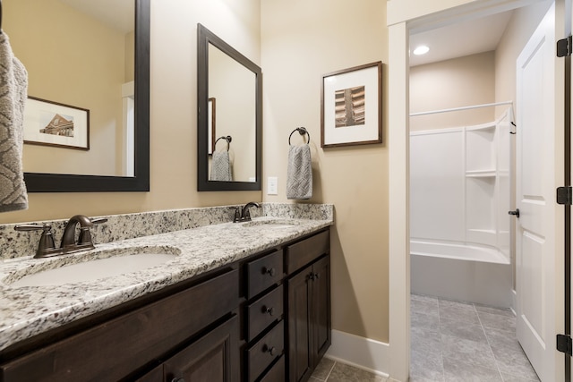 bathroom with tile patterned flooring, vanity, and  shower combination