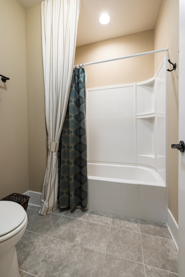 bathroom with tile patterned floors, shower / bath combination with curtain, and toilet