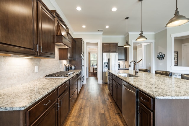 kitchen with appliances with stainless steel finishes, sink, dark hardwood / wood-style floors, hanging light fixtures, and a large island