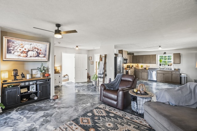 living room featuring a textured ceiling, sink, and ceiling fan