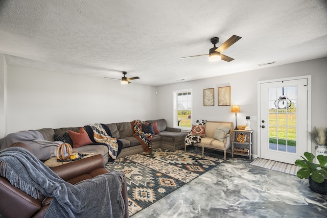 living room with ceiling fan and a textured ceiling