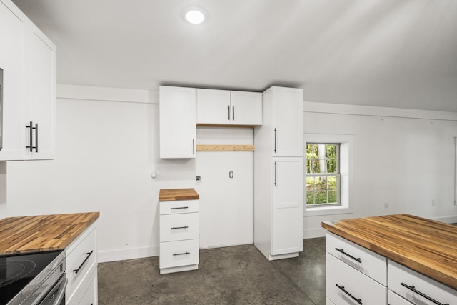 kitchen featuring white cabinets, wooden counters, and stainless steel range oven