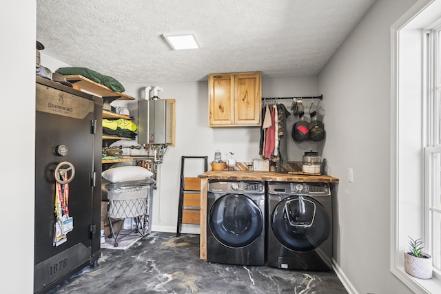 washroom with independent washer and dryer, a textured ceiling, and tankless water heater