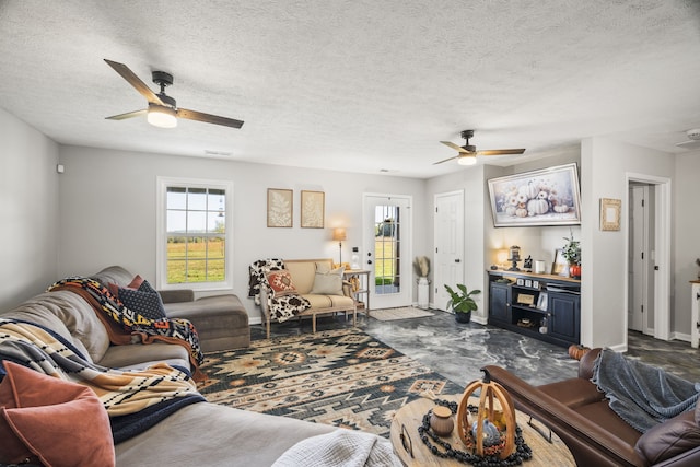 living room featuring ceiling fan and a textured ceiling