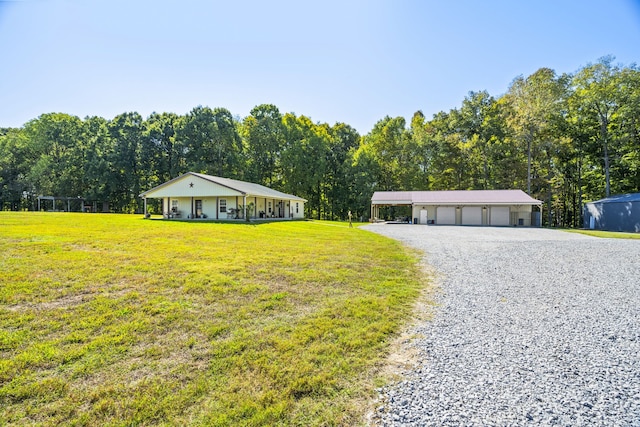 view of front of house featuring a front yard, a garage, and an outbuilding