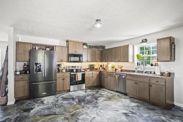 kitchen with stainless steel appliances, a textured ceiling, and sink