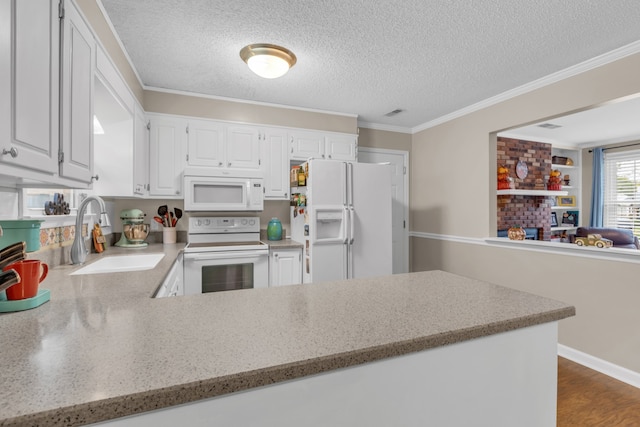 kitchen featuring white appliances, white cabinetry, sink, and kitchen peninsula