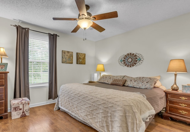 bedroom featuring ceiling fan, a textured ceiling, and hardwood / wood-style floors