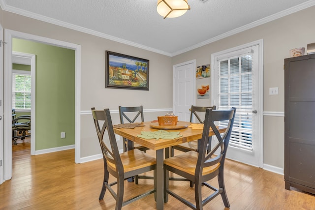 dining room featuring a wealth of natural light, light hardwood / wood-style flooring, and a textured ceiling