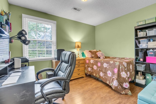 bedroom featuring a textured ceiling and wood-type flooring