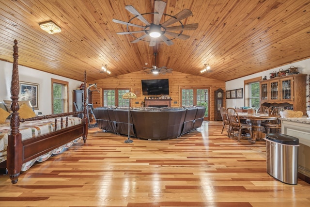 living room with wood ceiling, lofted ceiling, light wood-type flooring, and ceiling fan