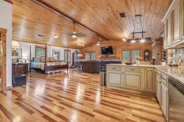 kitchen featuring a wealth of natural light, dishwasher, lofted ceiling with beams, and cream cabinetry