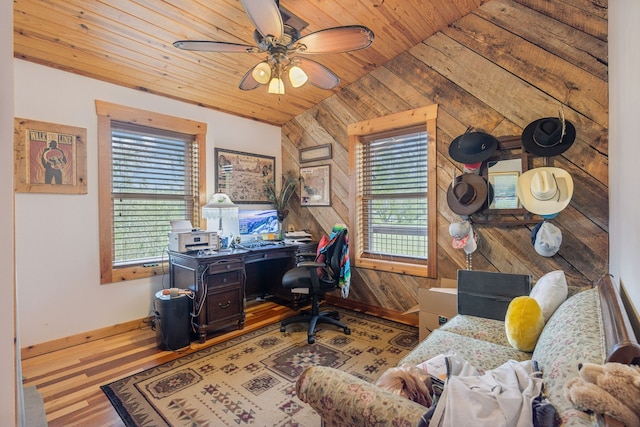 office area featuring wood walls, light hardwood / wood-style floors, ceiling fan, wooden ceiling, and vaulted ceiling