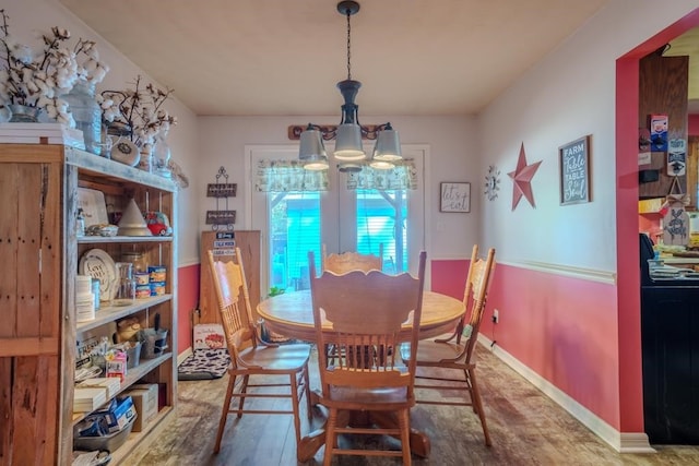 dining area with hardwood / wood-style flooring and a chandelier