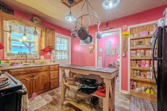 kitchen featuring black appliances, sink, tile countertops, a center island, and decorative light fixtures