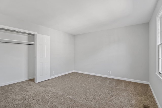 unfurnished bedroom featuring carpet floors and a closet