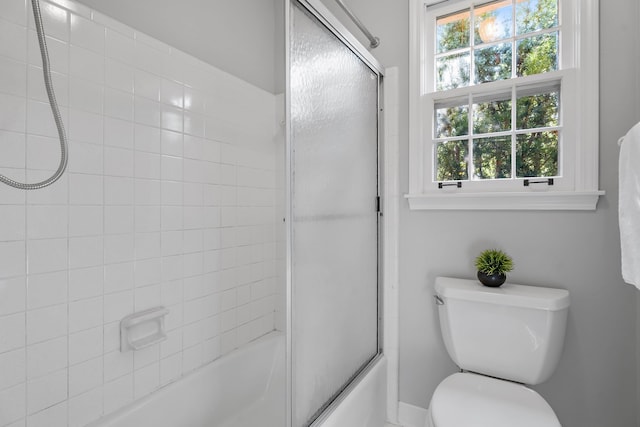 bathroom featuring shower / bath combination with glass door and toilet