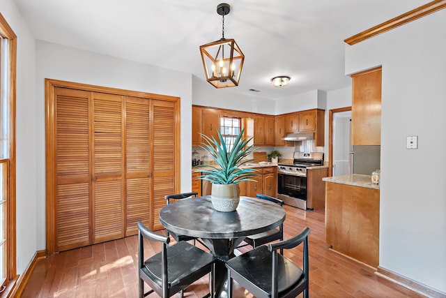 dining room with a notable chandelier and light wood-type flooring