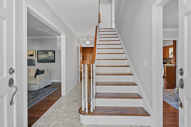 stairway with hardwood / wood-style floors and crown molding