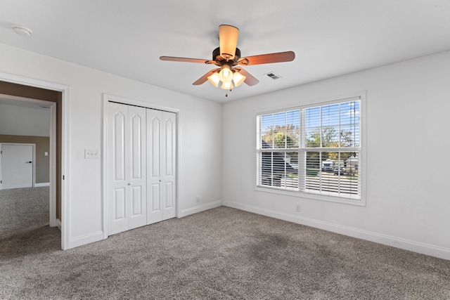 unfurnished bedroom with carpet floors, a closet, and ceiling fan