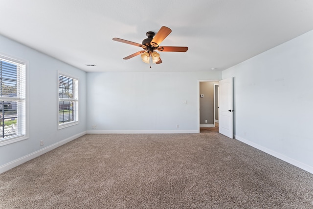 spare room with ceiling fan, a healthy amount of sunlight, and carpet