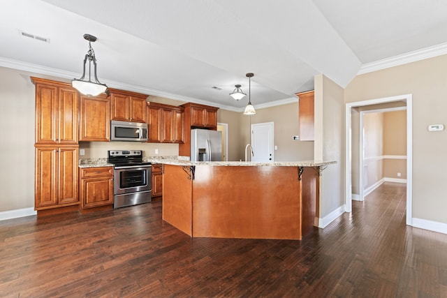 kitchen with appliances with stainless steel finishes, a breakfast bar, decorative light fixtures, and dark hardwood / wood-style floors