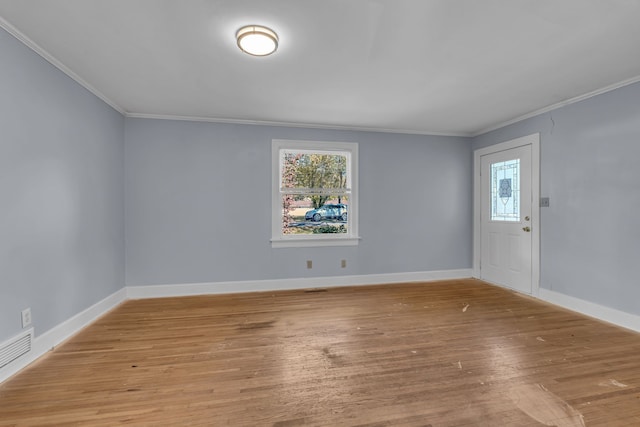 spare room with crown molding and light hardwood / wood-style flooring