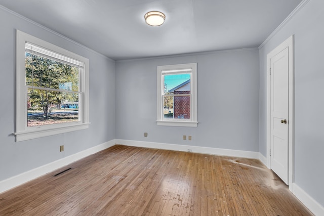 empty room featuring crown molding and light hardwood / wood-style flooring