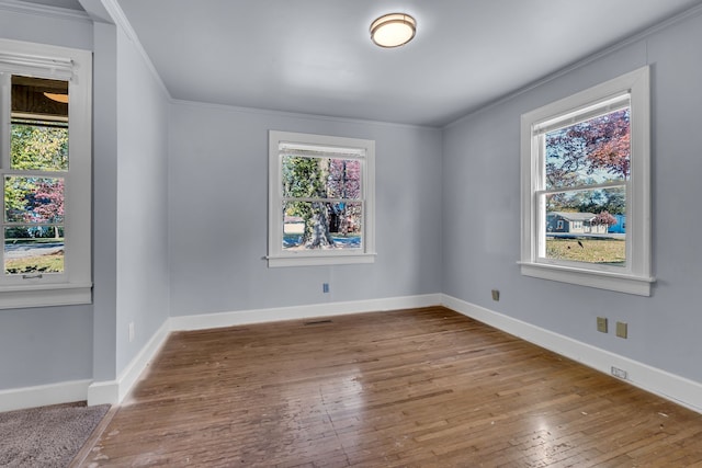 unfurnished room featuring crown molding, hardwood / wood-style flooring, and plenty of natural light