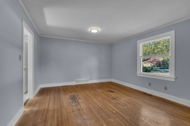 empty room with ornamental molding and wood-type flooring