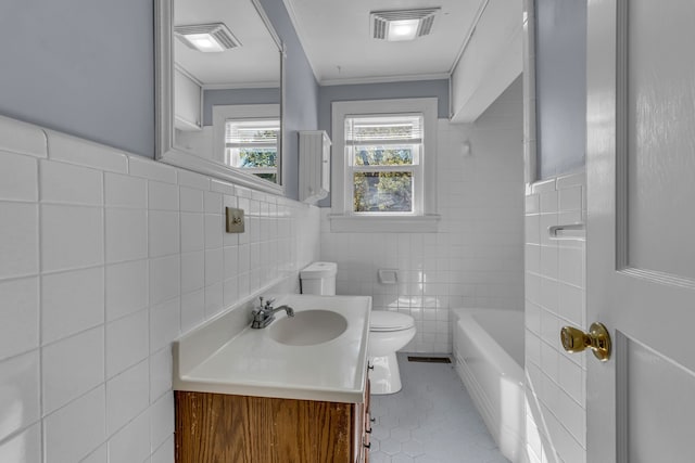 full bathroom with tile patterned floors, toilet, vanity, crown molding, and tile walls