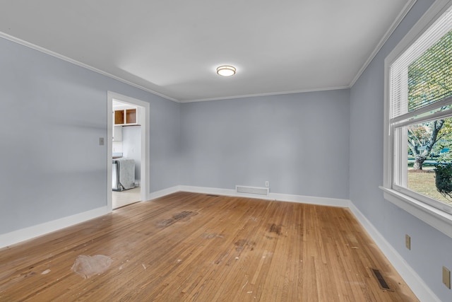 spare room with ornamental molding and light wood-type flooring