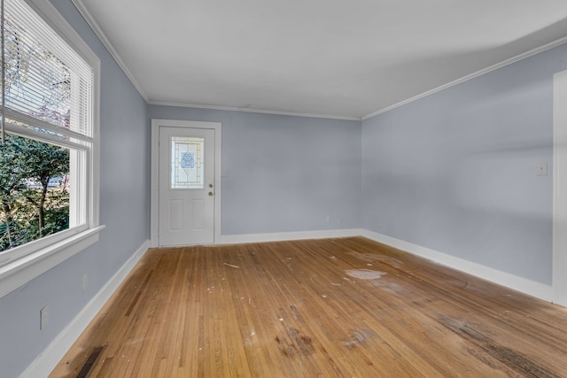 entrance foyer with ornamental molding and hardwood / wood-style floors