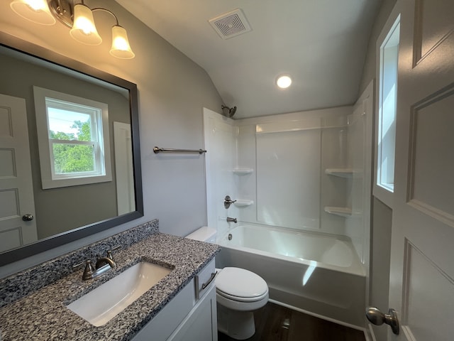 full bathroom featuring lofted ceiling, hardwood / wood-style flooring, toilet, vanity, and washtub / shower combination