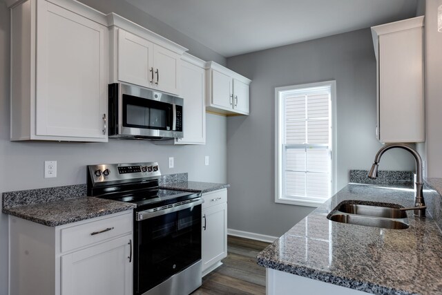 kitchen with white cabinetry, sink, dark wood-type flooring, and appliances with stainless steel finishes