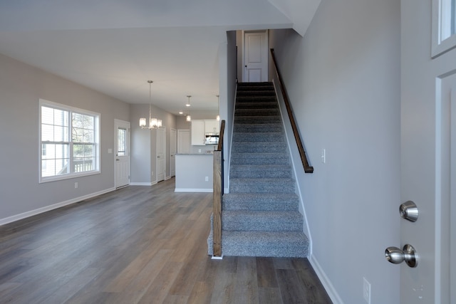 stairs with a chandelier and wood-type flooring